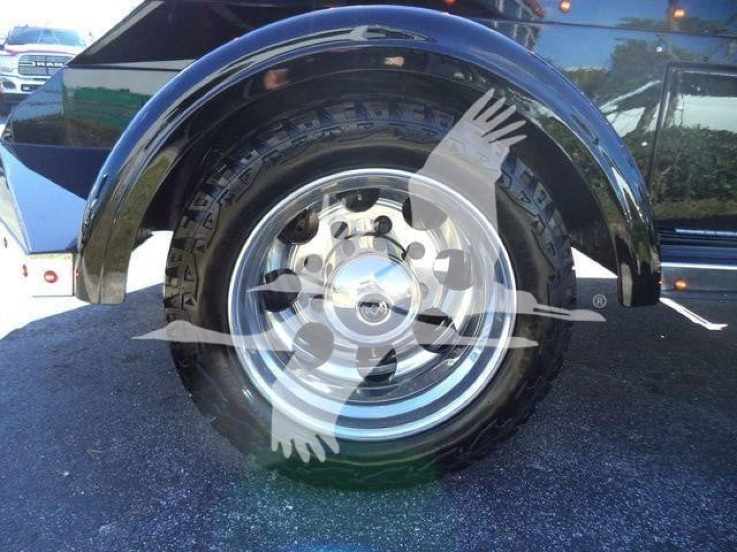 Wheel and fender view of a 2023 International CV truck showing chrome wheel with black tire and fender flare; reflections visible in glossy paint.