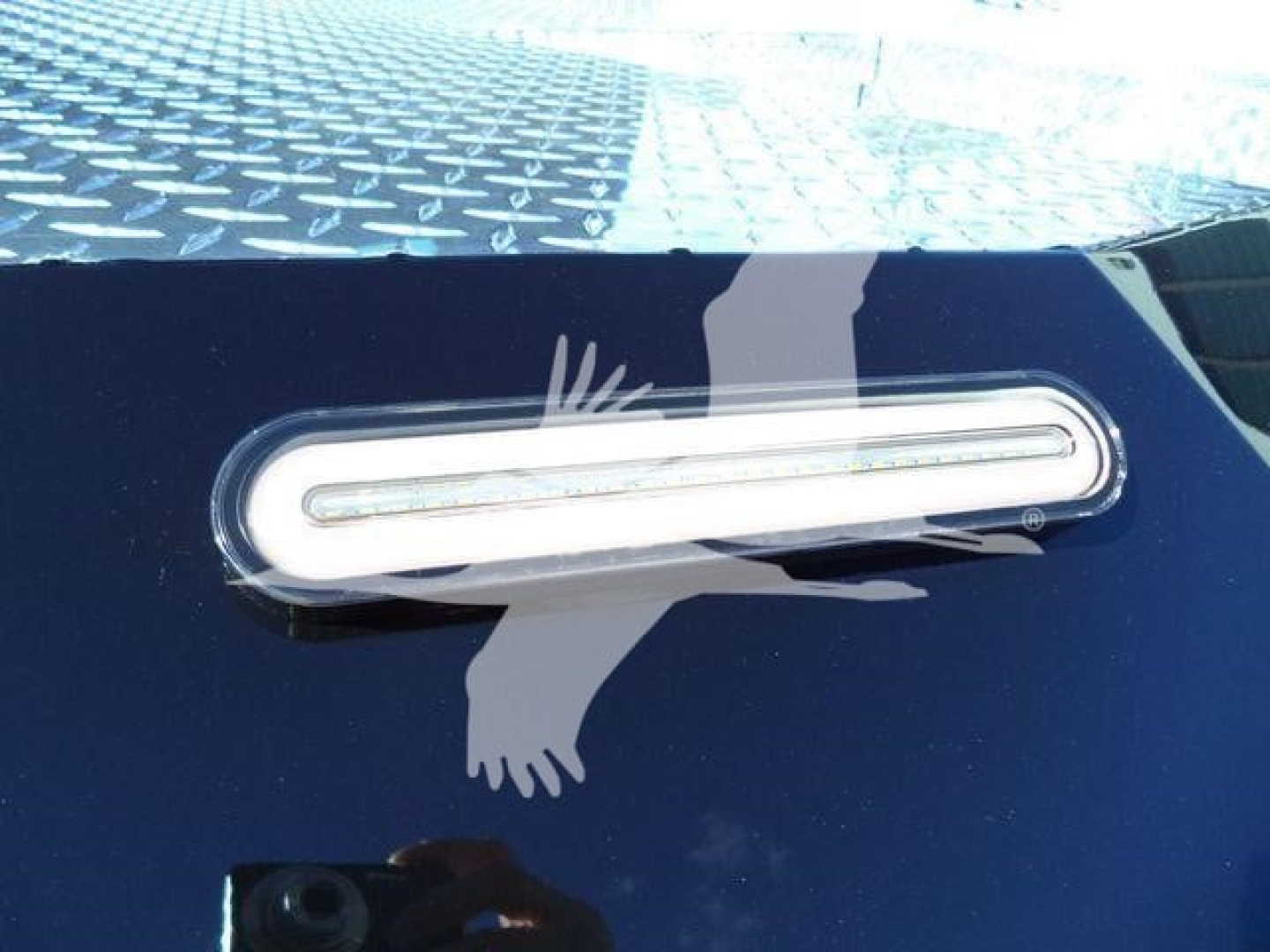 Trailer/vehicle exterior showing a horizontal oval side marker light on a dark surface.