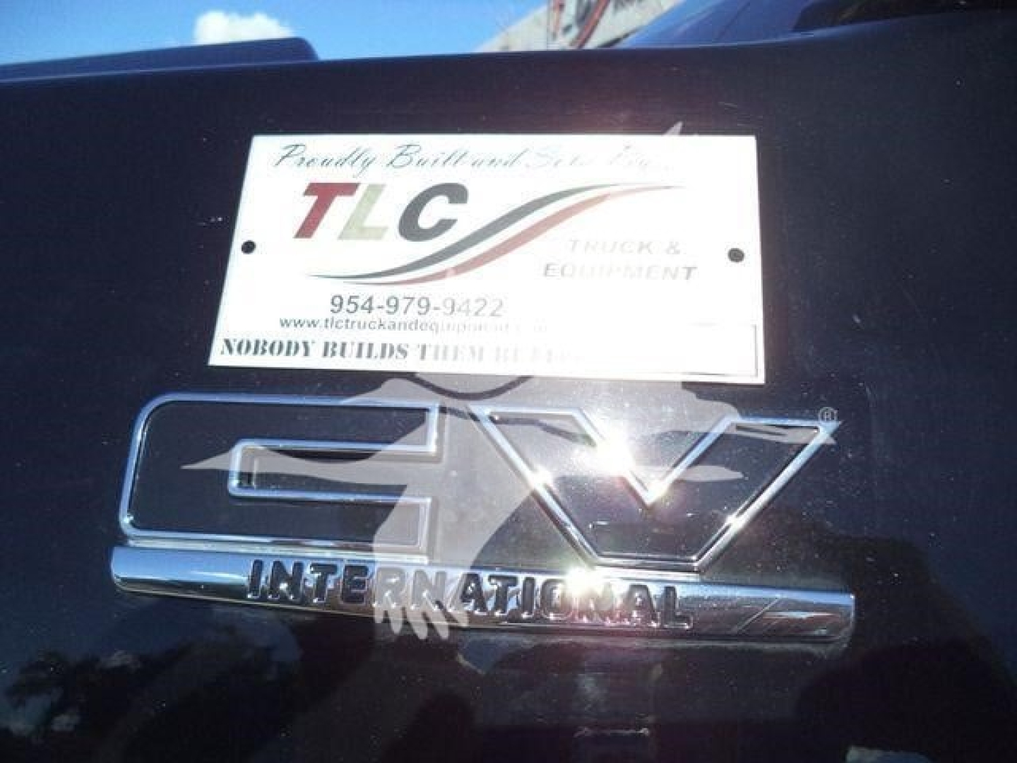 Truck badge and TLC plate with 'INTERNATIONAL' emblem on a new 2023 International CV truck, stock number STEPSIDEHAULER1FM, visible LTD sign