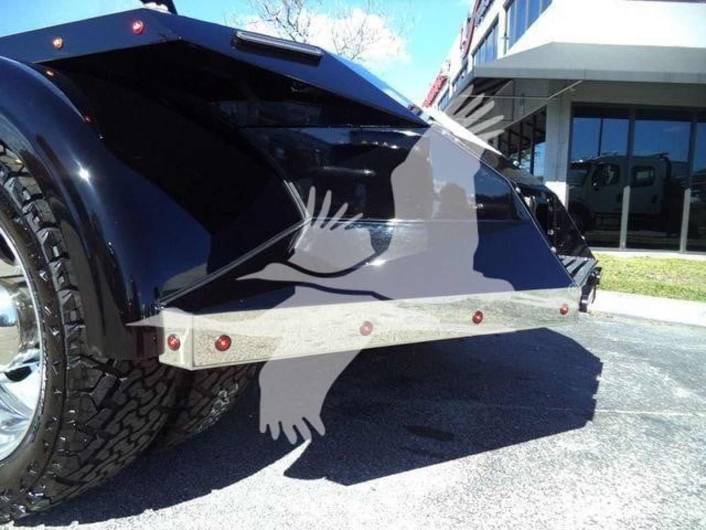 Truck bed with tailgate and large heavy-duty metal support, rear wheels visible; no legible brand text visible