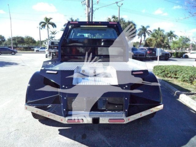 Truck bed of a new 2023 International CV tow truck, rear view with aluminum diamond-plate bed and mirrored tail lights.