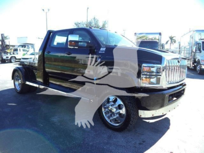 Truck cab and chassis of a 2023 International CV with dual rear wheels, black exterior, chrome wheels, and visible front grille.