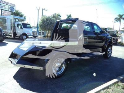 Tricked-out black pickup with a custom side-car trailer or flatbed module, front angled view, showroom lot in background.