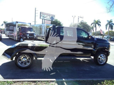 Truck bed with a black cab over a pickup, side view showing the truck on a lot