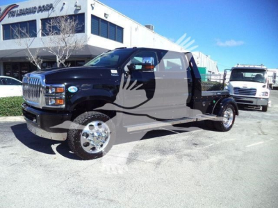 Truck in a dealership lot showing a black cab and chassis with chrome wheels, International CV