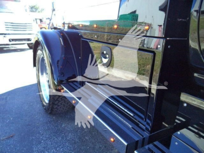 Truck fender and chrome wheel on blue International CV truck showing polished metal surface and side panel details.