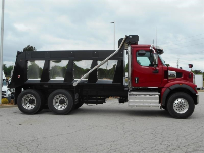 Western Star 47X dump truck side view showing red cab, black dump body, three-axle rear with chrome steps and hydraulic hoist.