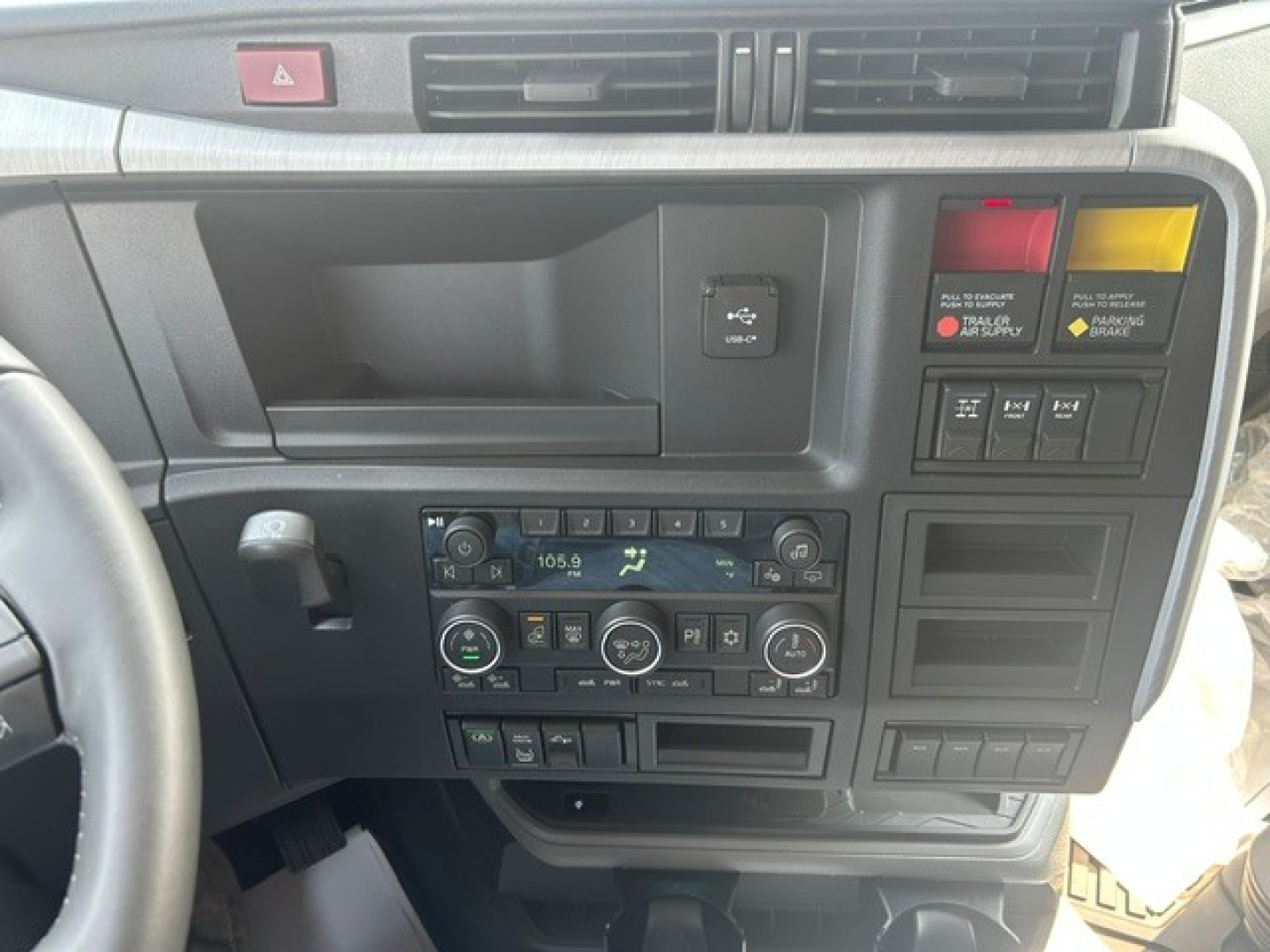 Dashboard of a Volvo VNL64T840 interior showing radio, climate controls, and switch panels.