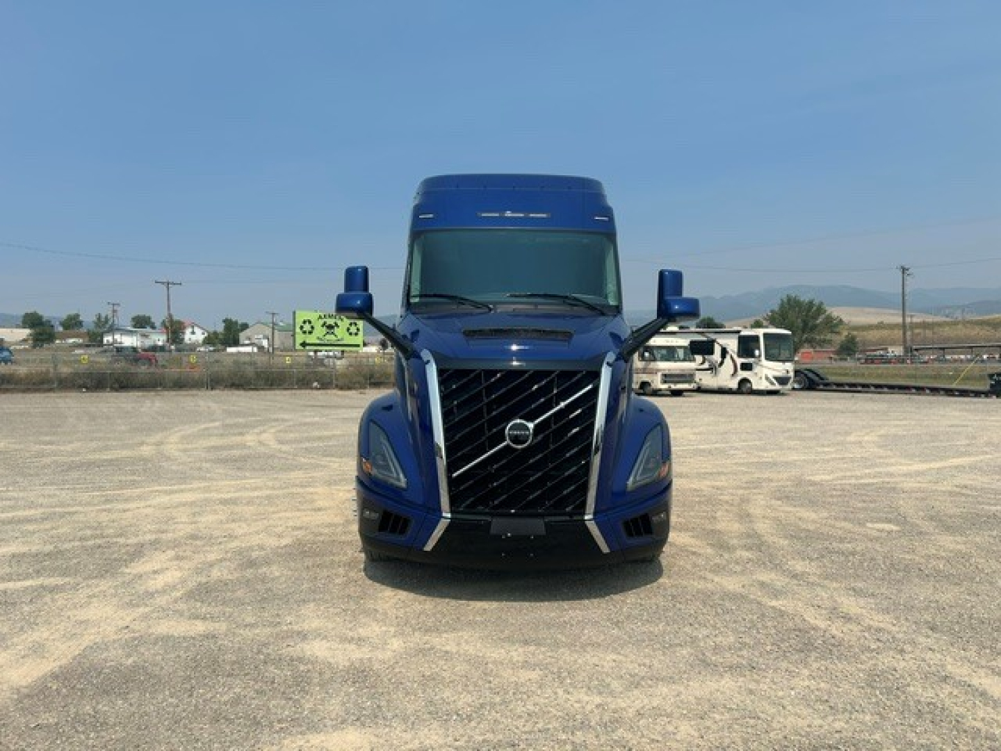 Volvo VNL64T840 truck front view showing bold black grille, blue cab, and sleeper cab with large windshield.