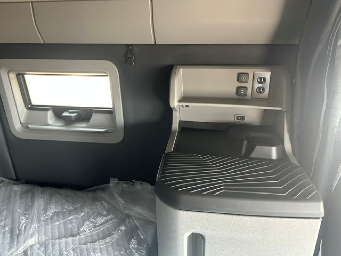 Volvo VNL64T840 interior cab area showing window, control panel, and seating surface with text and switches.