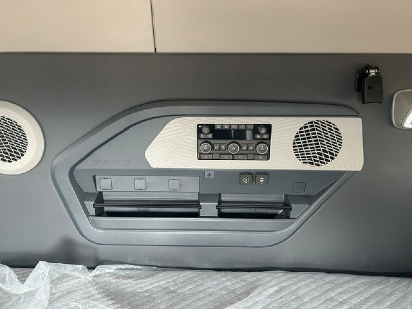 Volvo VNL64T840 sleeper cab interior rear wall showing control panel, two air vents, and speaker grilles with storage compartments.