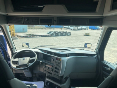Truck cabin interior of a new 2027 Volvo VNL64T840, front dashboard with steering wheel, center console, and multiple control panels visible.