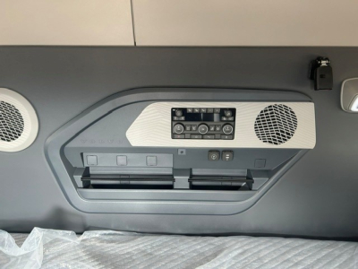 Volvo VNL64T840 sleeper cab interior rear wall showing control panel, two air vents, and speaker grilles with storage compartments.
