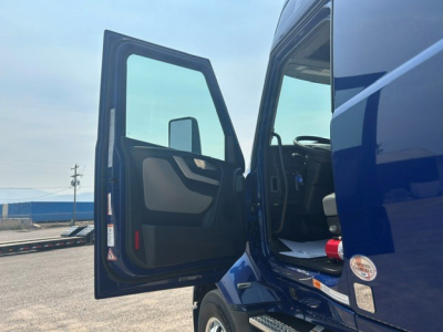 Volvo VNL64T840 truck cab with open driver door, interior visible.