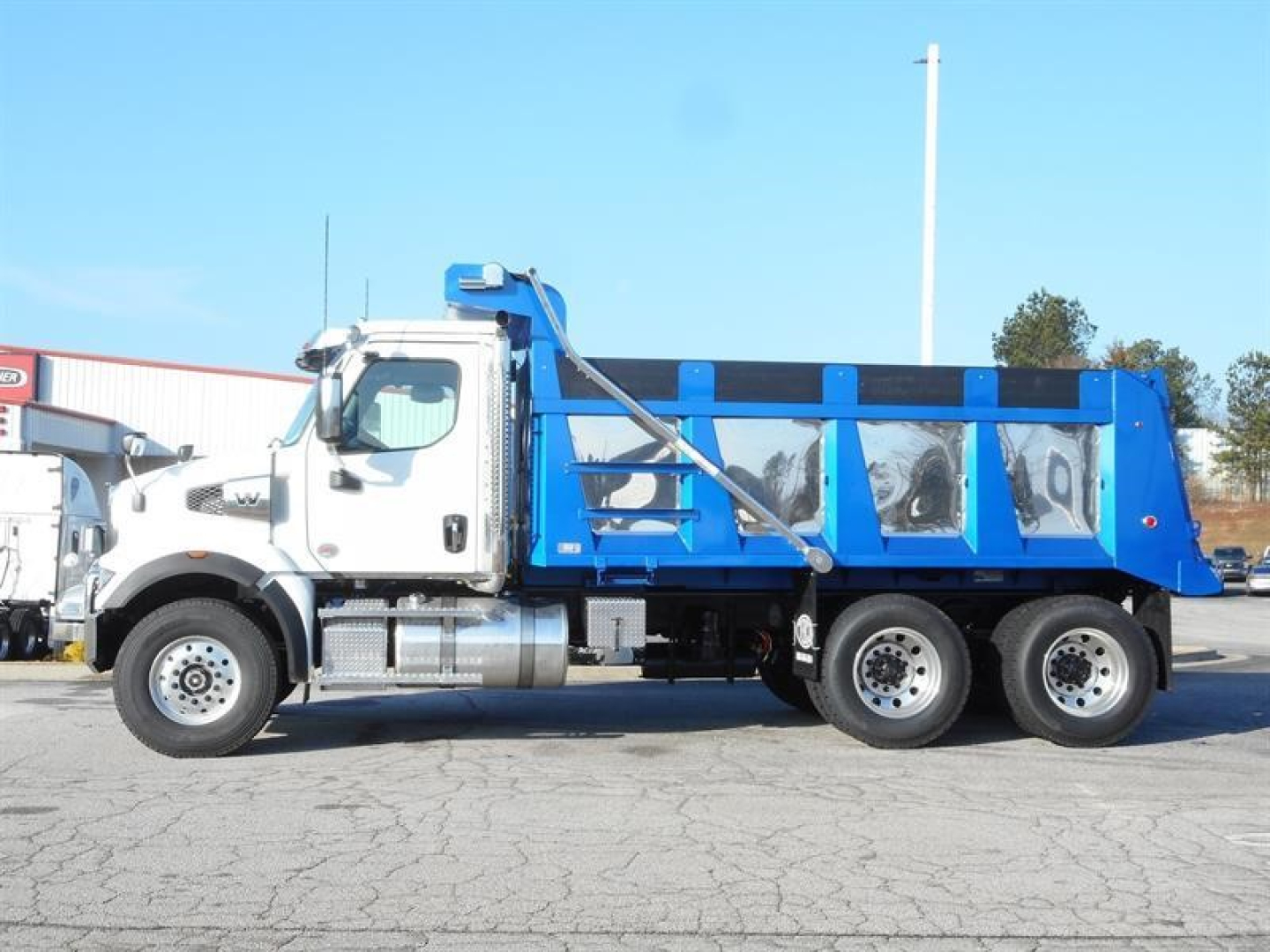 Western Star 47X dump truck side profile showing blue dump bed and white cab, VIN 3BJHBPDV9VDXK0309, stock 355207, new.