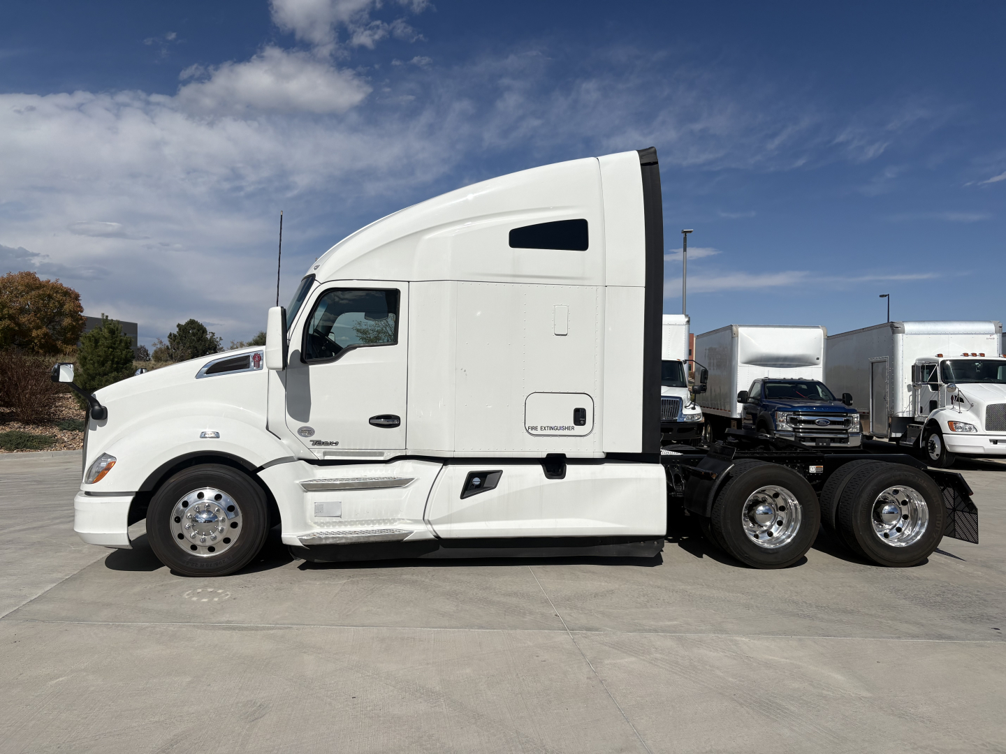 Kenworth T680 tractor in side profile showing sleeper cab, white exterior, dual rear axles, and chrome wheels.