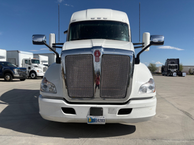Front view of a white 2021 Kenworth T680 semi-truck with large chrome grille, dual mirrors, and a Utah license plate; badge visible on center of grille.