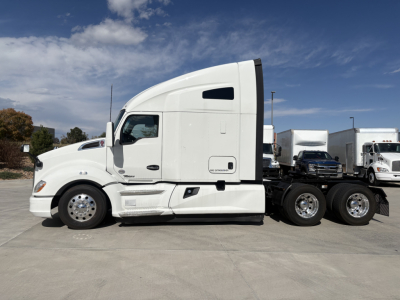 Kenworth T680 tractor in side profile showing sleeper cab, white exterior, dual rear axles, and chrome wheels.