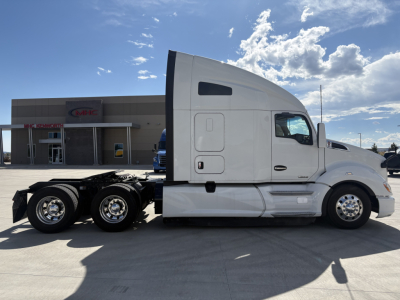 Kenworth T680 tractor in profile view showing cab and rear axles with chrome wheels.