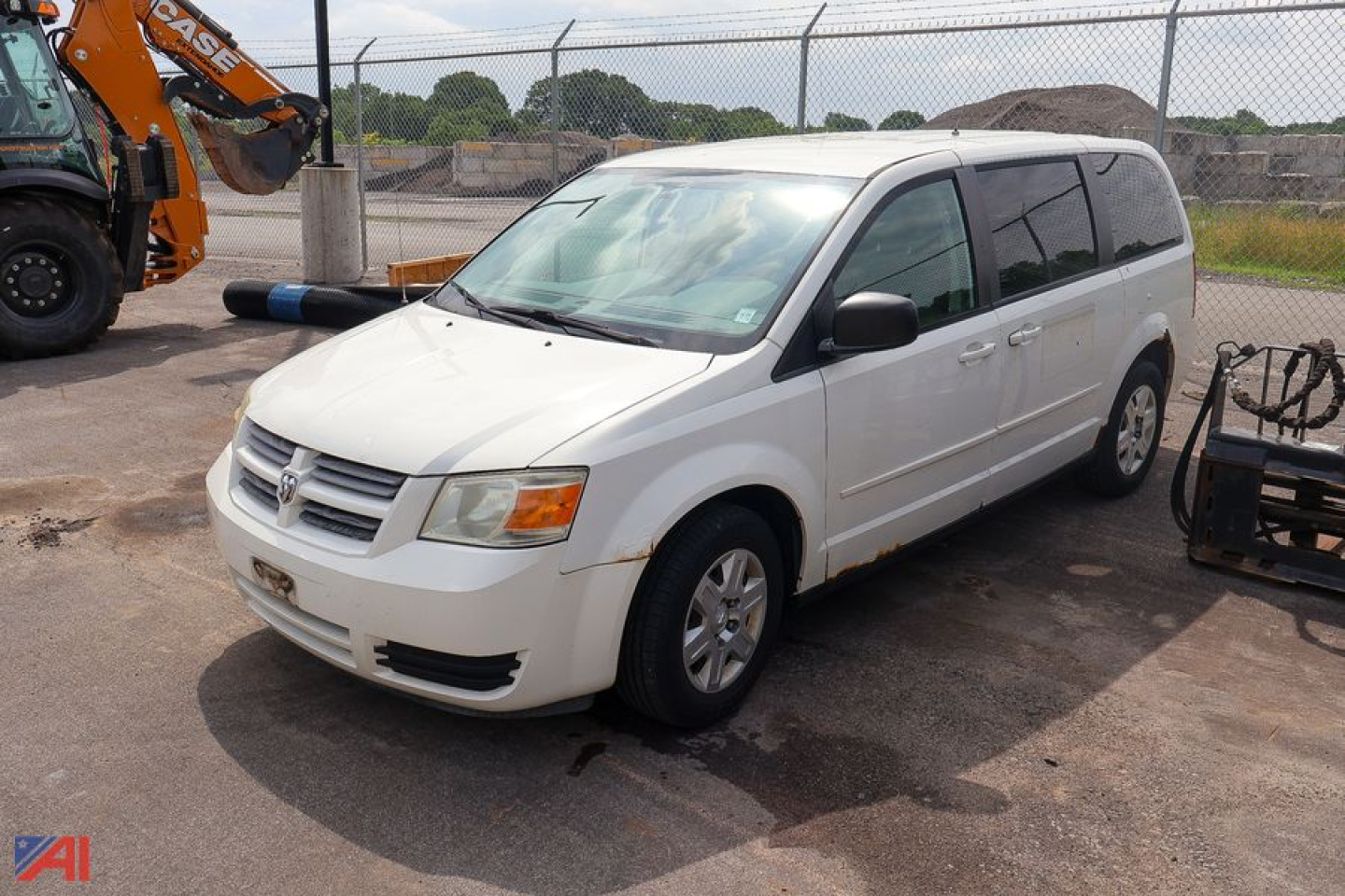 2009 Dodge Grand Caravan minivan in light color, front three-quarter view, showing body and windows; visible front grille and headlights.