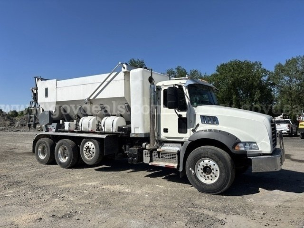 Mack GU813 mixer truck viewed from side showing large mixer body and cab, text not legible on decals.