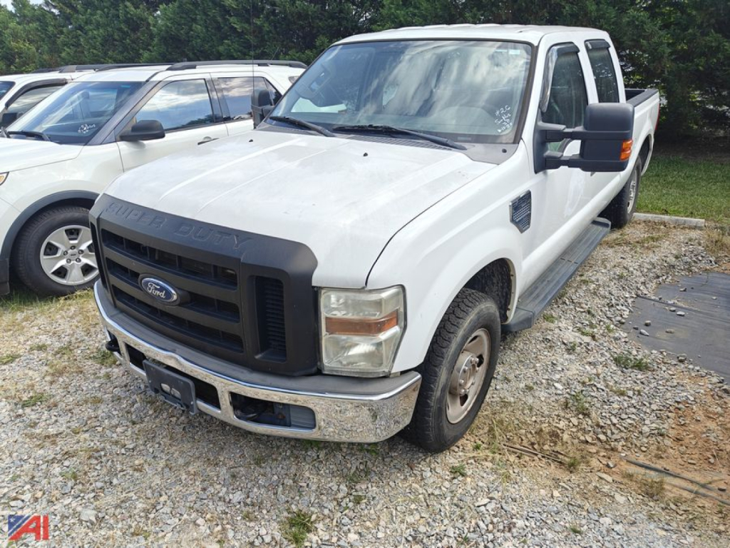 Ford F-250 Super Duty truck in a used lot showing front grille and bumper, 6-spoke wheels, extended cab with steps.