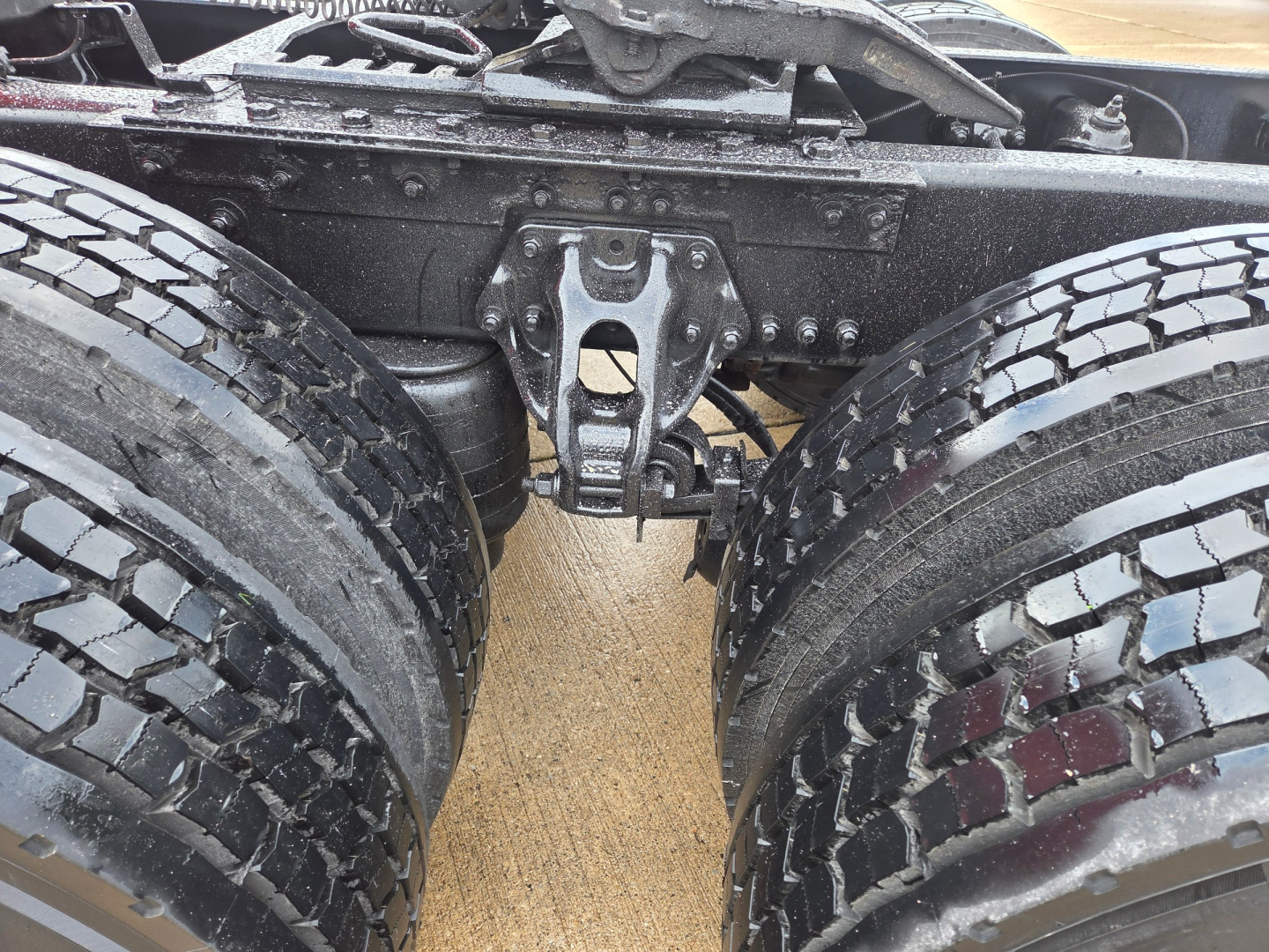 Kenworth T680 rear chassis showing dual rear axles and suspension components with tires.