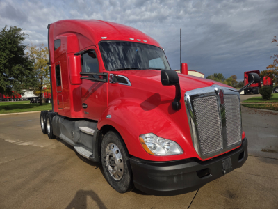 Kenworth T680 tractor red cab in-service showing the front grille and headlights. No visible text on labels or stickers in view.