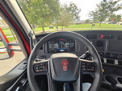 Kenworth T680 truck interior steering wheel and dashboard view showing digital gauges and controls.