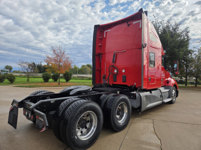 Kenworth T680 sleeper cab tractor in red with dual rear axles and black tires, side view showing tractor frame and rear wheels.