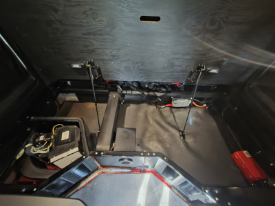 Kenworth T680 under-bunk area with battery, wiring, and frame components visible.