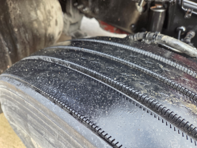 Kenworth T680 wheel and tire close-up showing tread and mud in-service condition.