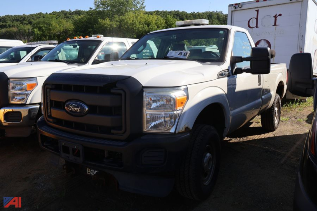 Ford F-250 Super Duty pickup truck in front with black grille and large side mirrors; other trucks visible in background.