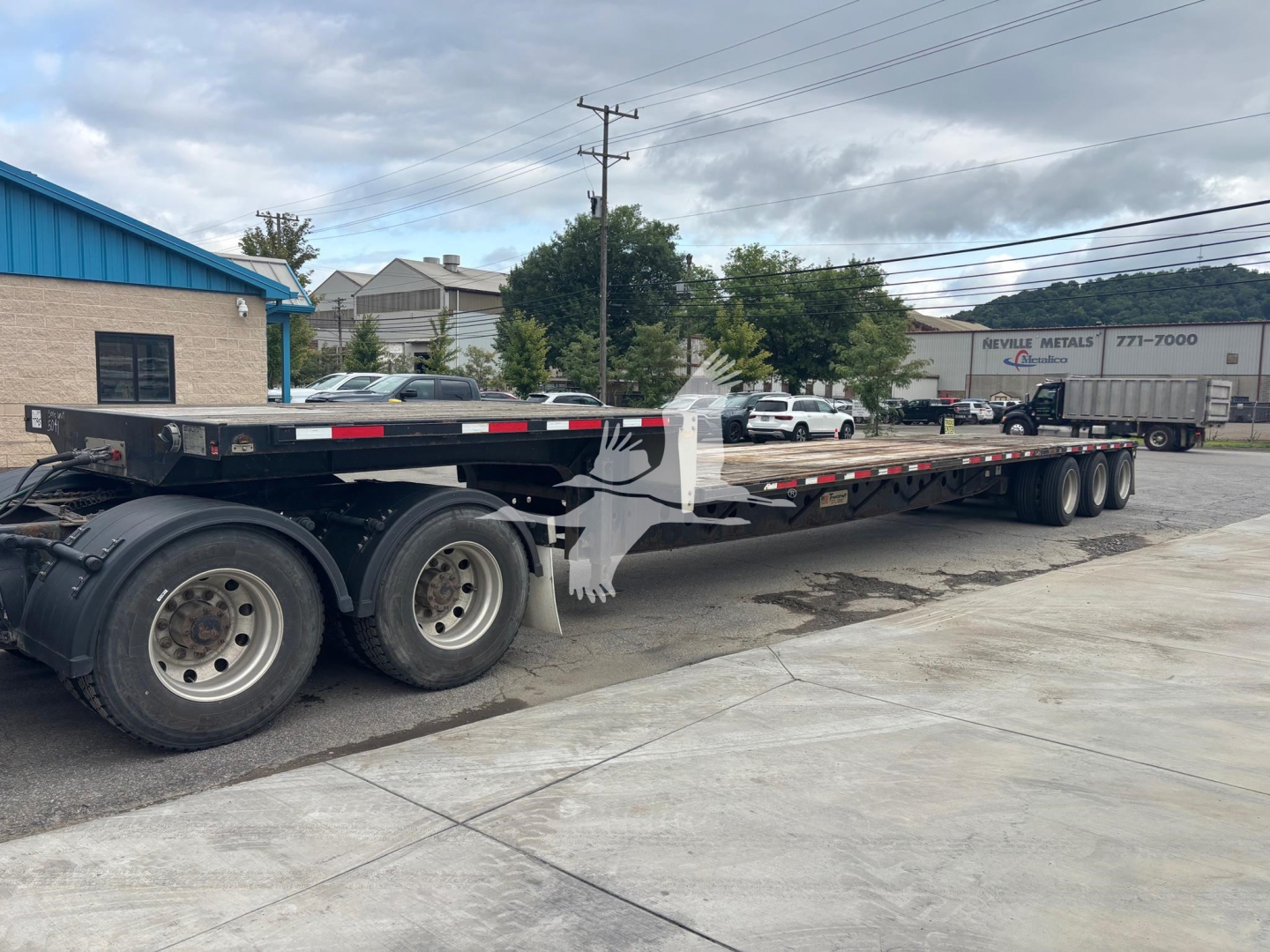 Transcraft DTL-3000 flatbed trailer showing long low deck and dual rear axles with multiple wheels.