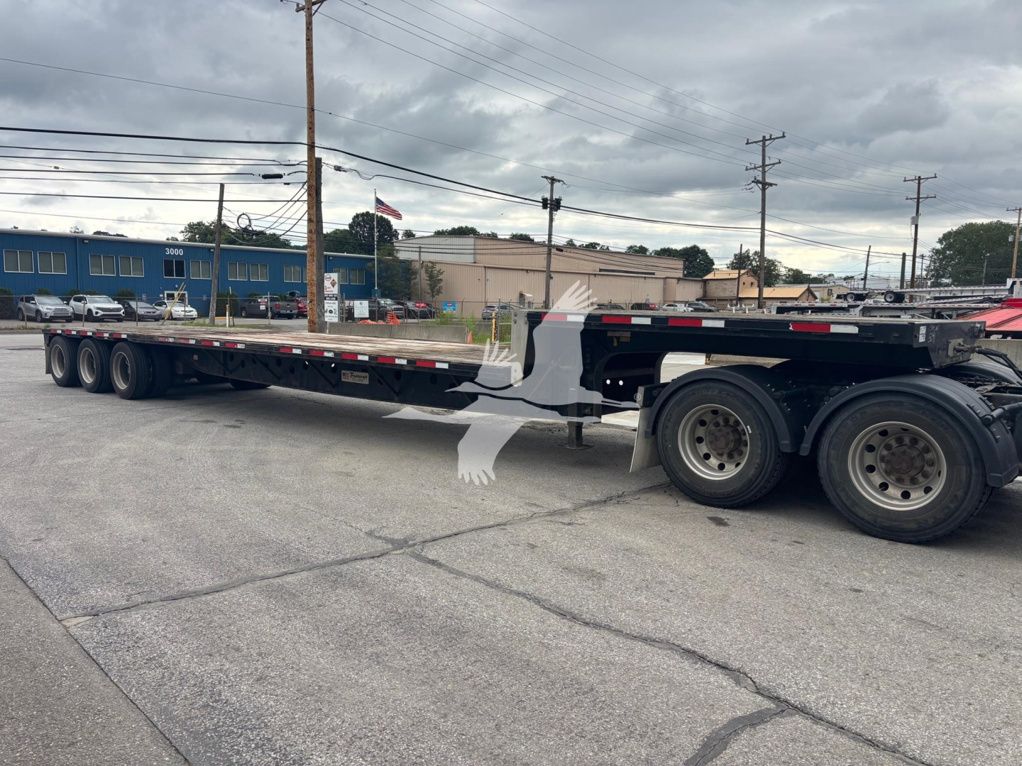 Trailer side view showing a long flatbed/dropside Transcraft DT L-3000 style trailer with multiple axles and black frame.