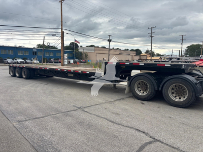 Trailer side view showing a long flatbed/dropside Transcraft DT L-3000 style trailer with multiple axles and black frame.