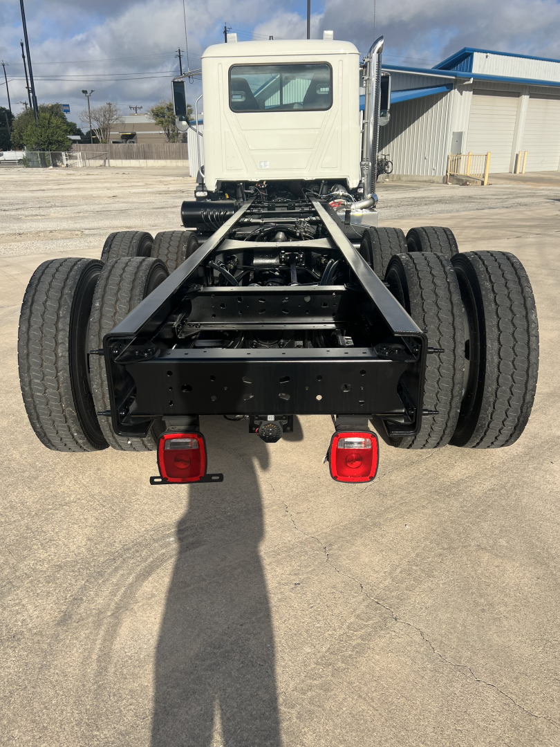 Mack GR64B cab and chassis rear view showing dual rear axles and frame with taillights.