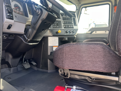 Cab and chassis interior of a 2026 Mack GR64B showing driver seat and dashboard with steering wheel and instrument cluster