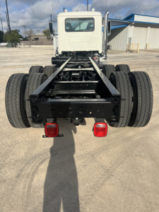Mack GR64B cab and chassis rear view showing dual rear axles and frame with taillights.