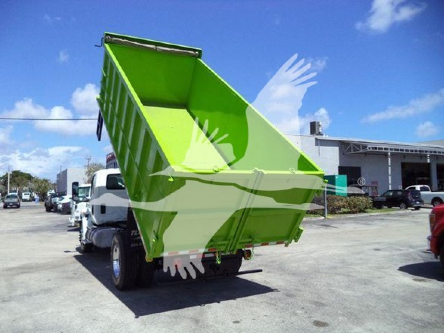 Dump truck bed tilted upward showing bright lime green dump body with hydraulic lifting on a white cab truck.