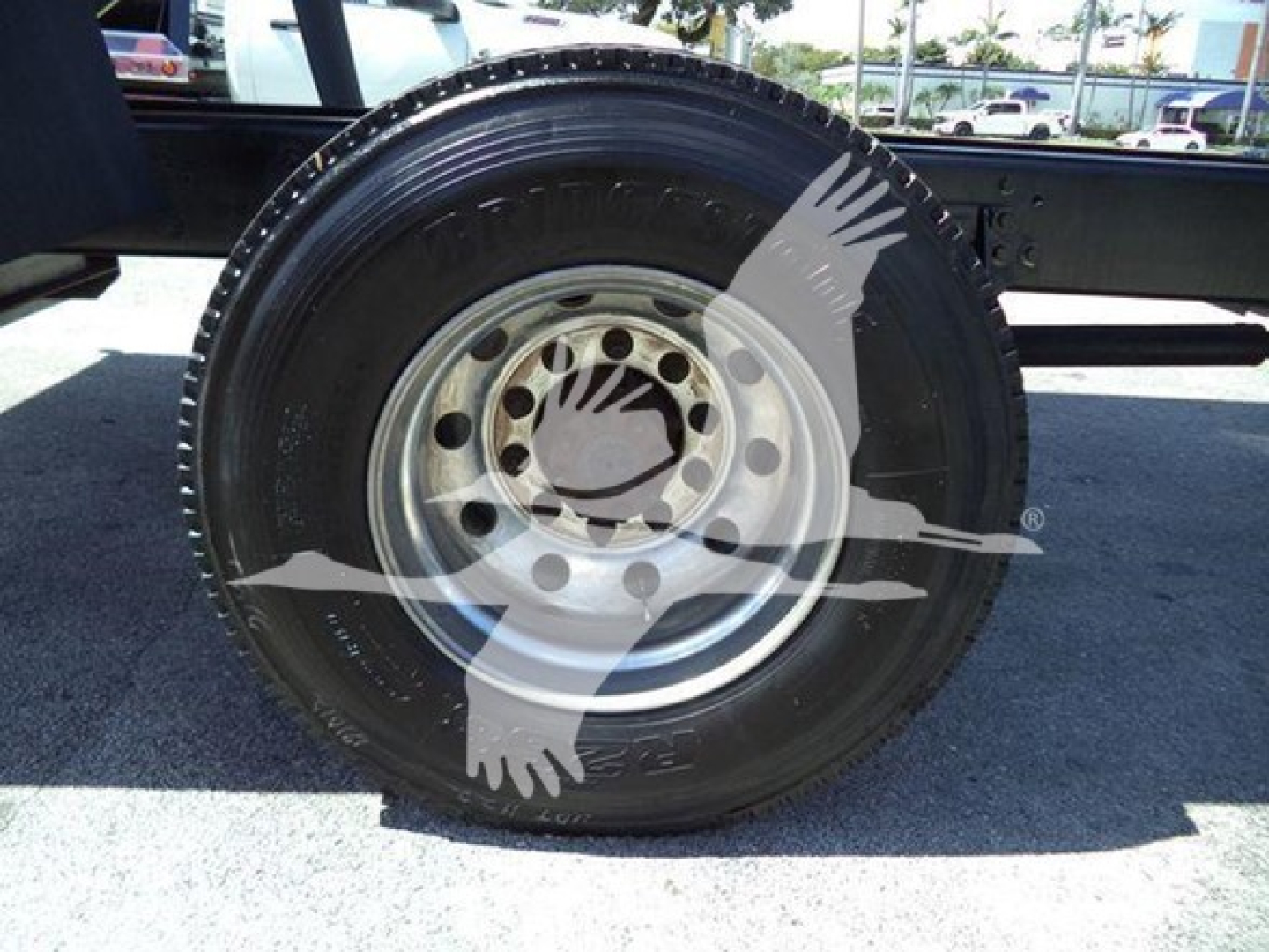 Truck wheel and tire on a dump truck with metal rim and black tire.