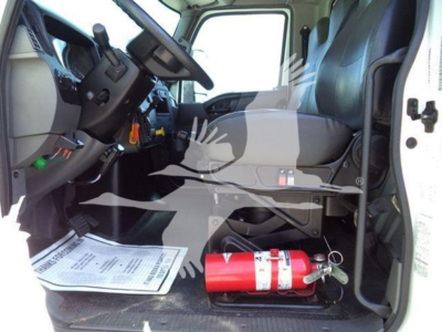 Interior cab view of a 2020 International MV dump truck showing steering wheel, driver's seat, dashboard, and a red fire extinguisher on the floor.