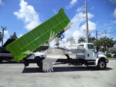 Dump truck in service showing green dump bed raised, International MV cab, side view with stock number T98791 and VIN 3HAEUMML1LL198791.