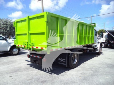 Dump truck with lime green dump body and white cab, rear view showing loading bed and taillights.
