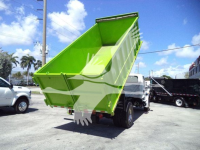 Dump truck in a lot showing bright green dump bed raised, International badge not visible.