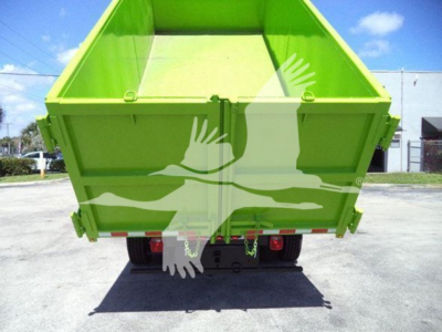 Green dump truck bed rear view with tailgate latches and bumper; no visible text on image aside from general structure.