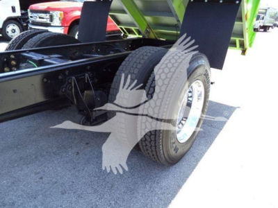 Truck chassis with dual rear tires and green dump body visible; black undercarriage and wheel rim detail.