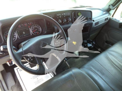 Cab interior of a 2020 International MV dump truck showing steering wheel, dashboard gauges, and seats with visible controls.