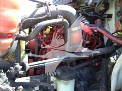 Engine bay of a 2020 International MV dump truck showing hoses, belts, and components in view.