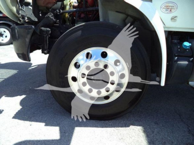 Truck wheel and front fender view showing front tire and polished aluminum dual rear hub with bolt pattern and white fender flare.